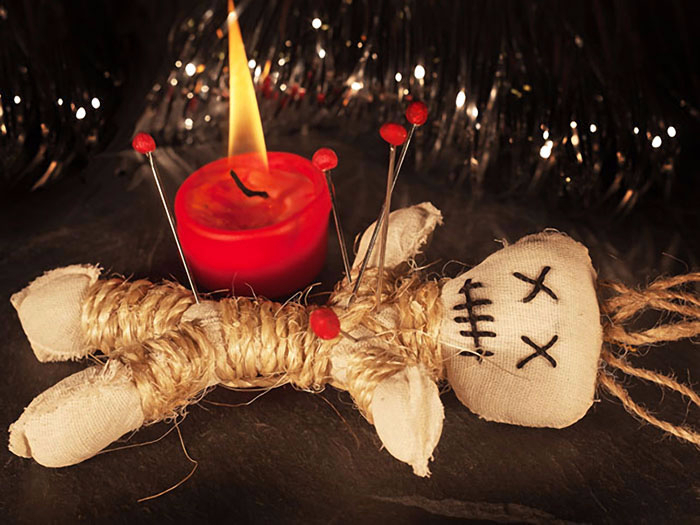 A red candle and a voodoo doll.